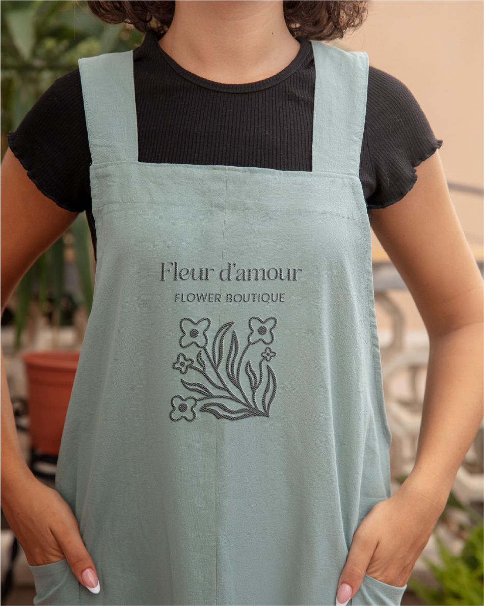 APRON image of a woman wearing an apron with the Fleur logo in the middle